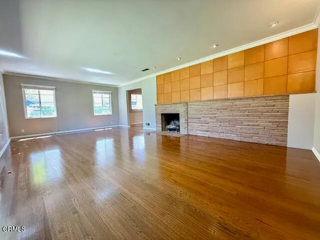 a view of empty room with wooden floor and fireplace