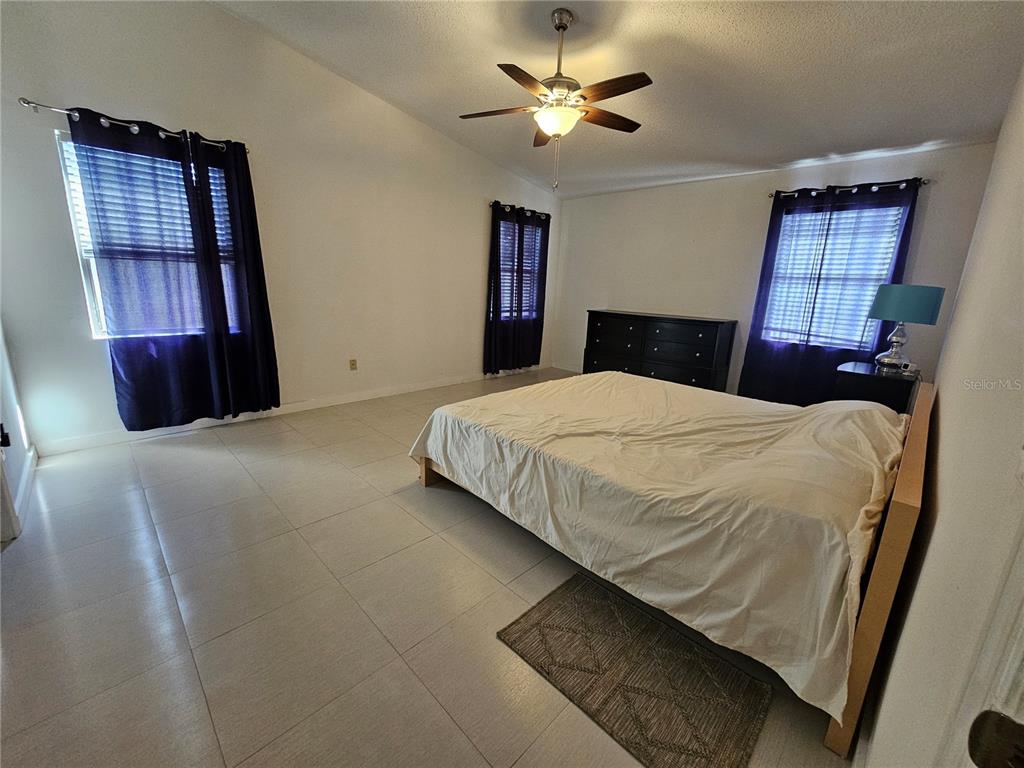 1885 Feather Tree Circle Clearwater, FL 33765 - Photo 13 of 18 a bedroom with a large bed and a chandelier
