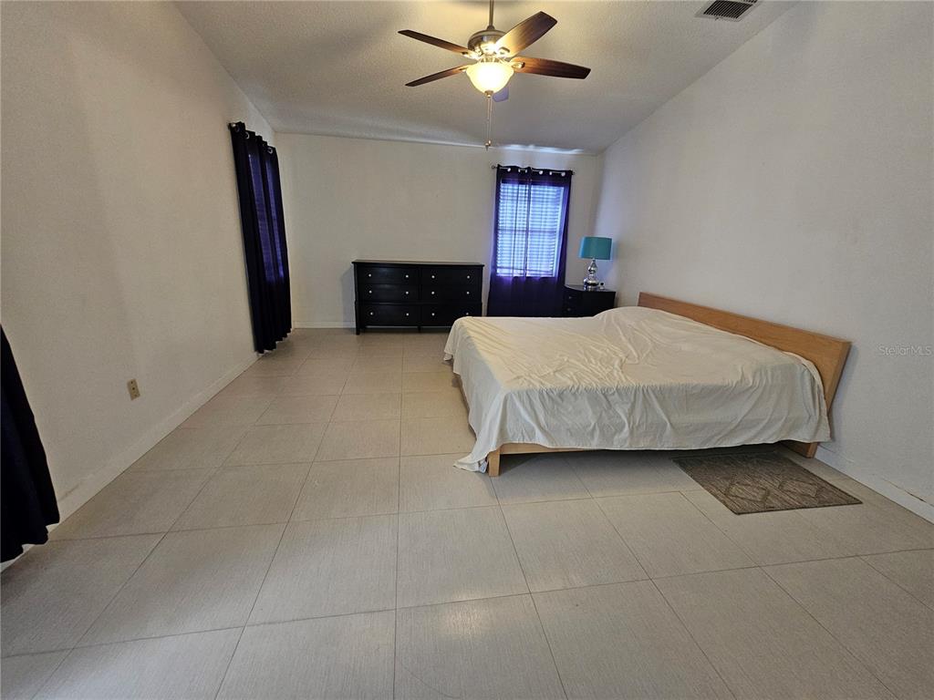 1885 Feather Tree Circle Clearwater, FL 33765 - Photo 14 of 18 a bedroom with a bed and a ceiling fan