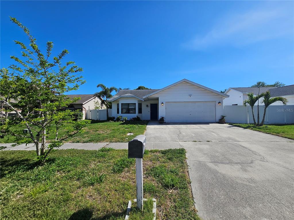 1885 Feather Tree Circle Clearwater, FL 33765 - Photo 2 of 18 a front view of a house with a yard and garage