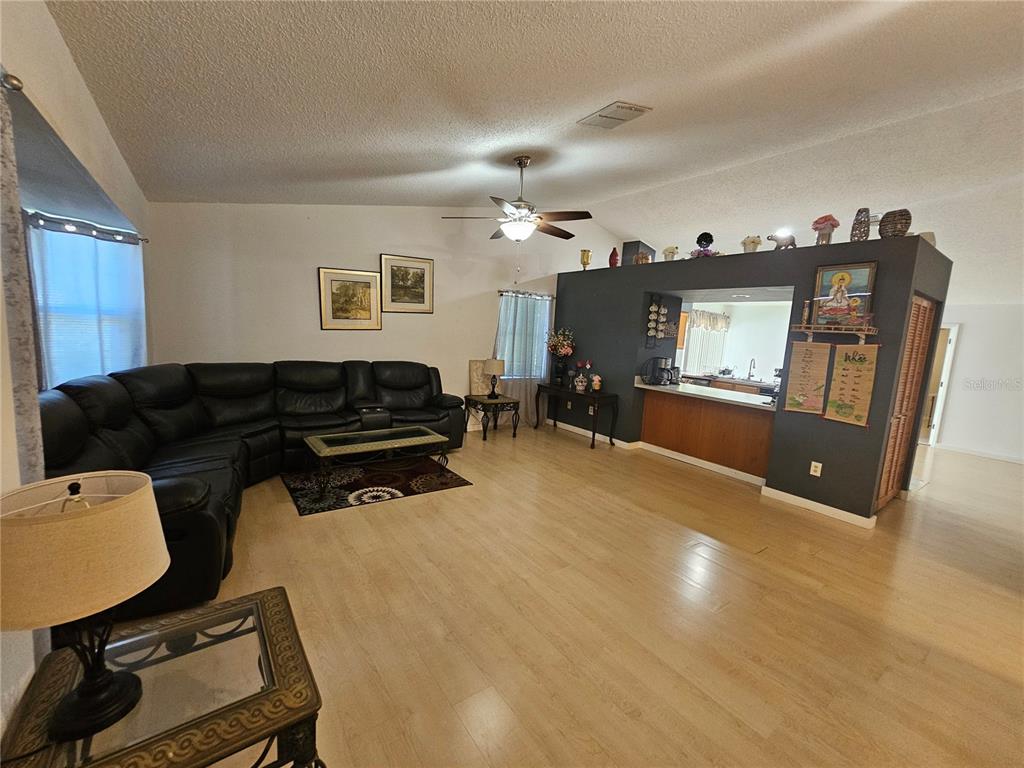 1885 Feather Tree Circle Clearwater, FL 33765 - Photo 3 of 18 a living room with furniture a chandelier and a flat screen tv