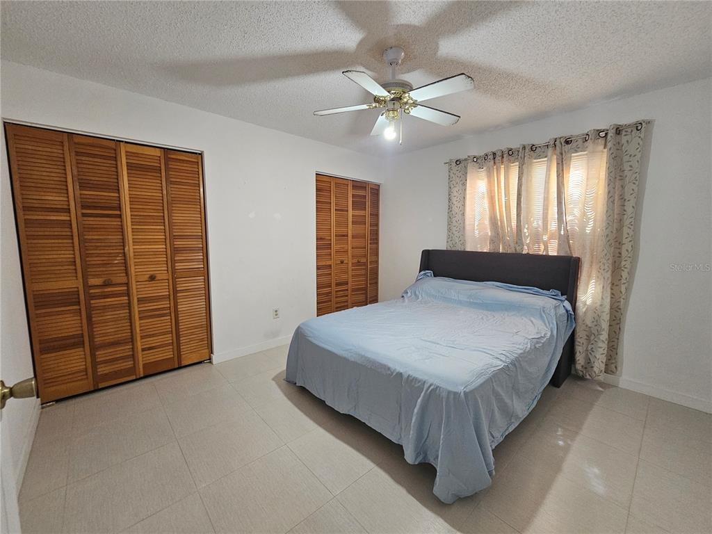 1885 Feather Tree Circle Clearwater, FL 33765 - Photo 7 of 18 a spacious bedroom with a bed and a chandelier