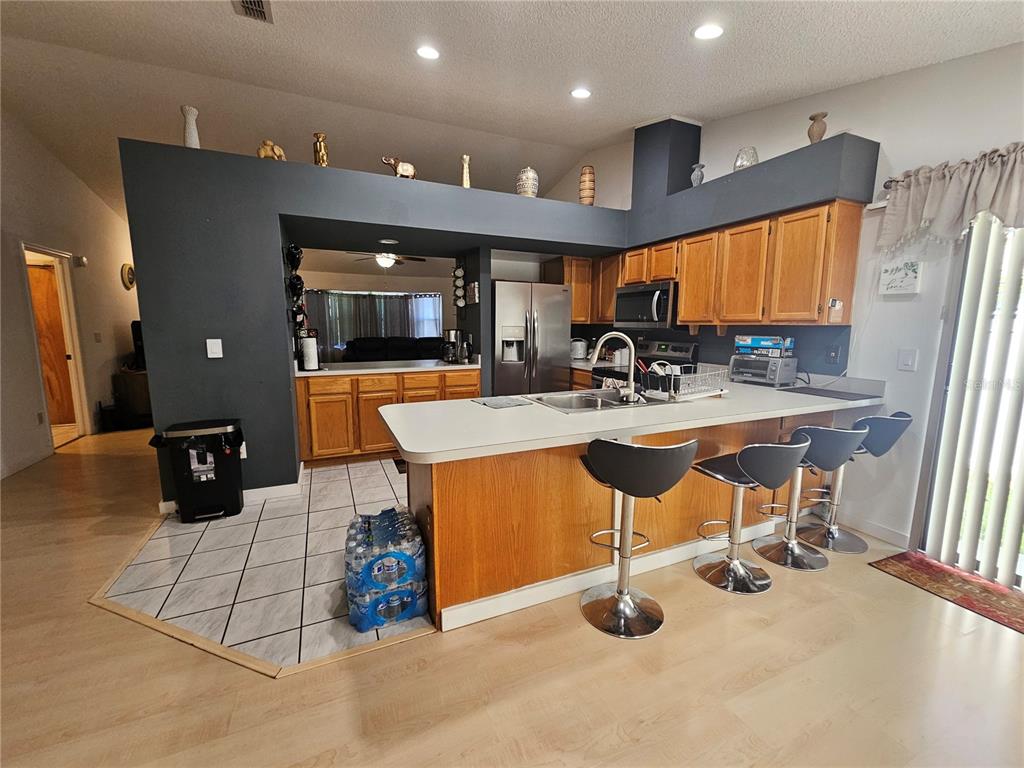 1885 Feather Tree Circle Clearwater, FL 33765 - Photo 10 of 18 a kitchen with stainless steel appliances kitchen island granite countertop a sink and a refrigerator