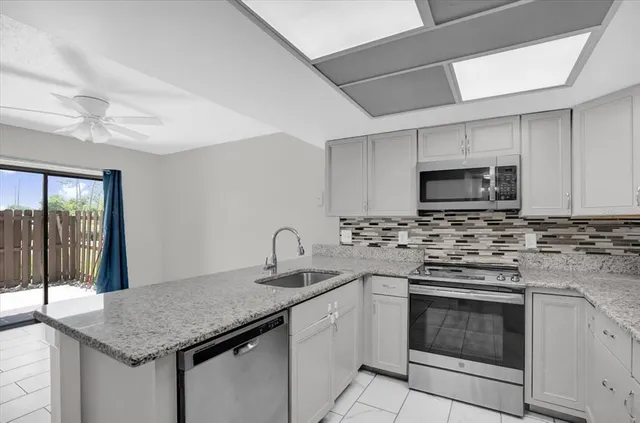 a kitchen with stainless steel appliances granite countertop a sink stove and cabinets