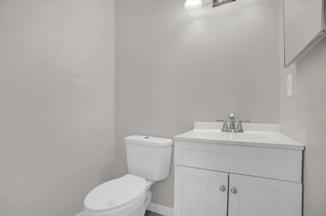 a bathroom with a toilet sink vanity and mirror