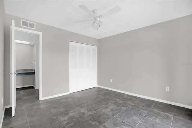 an empty room with a ceiling fan and a window