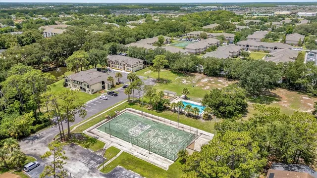 an aerial view of residential houses with outdoor space and trees
