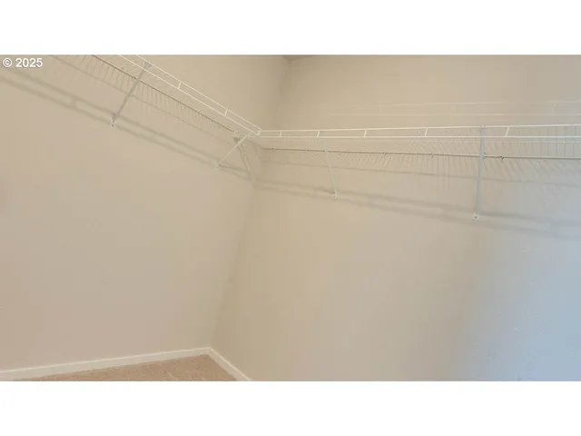 a open living room with a white wall and a refrigerator