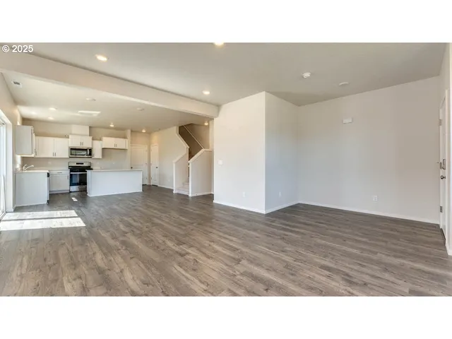 a kitchen with stainless steel appliances kitchen island granite countertop a stove a sink a refrigerator and white cabinets