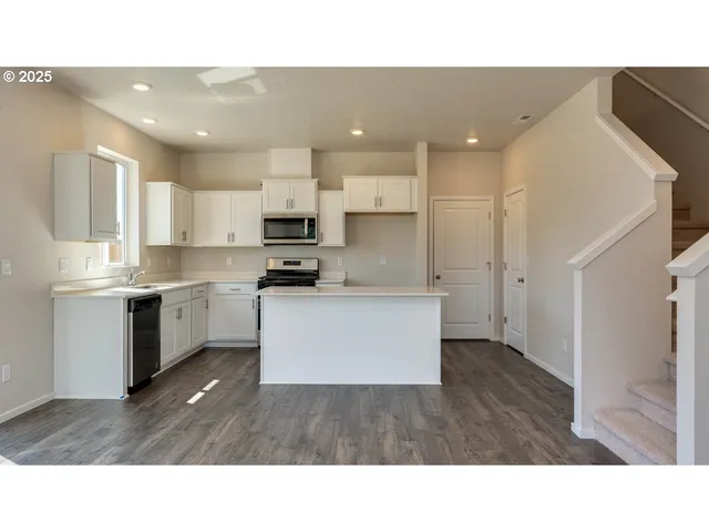 a open kitchen with white cabinets and stainless steel appliances