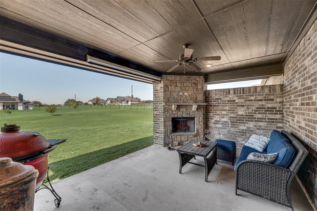 416 Christian Way Azle, TX 76020 - Photo 19 of 23 View of covered patio featuring a ceiling fan, an outdoor living space with wood burning fireplace
