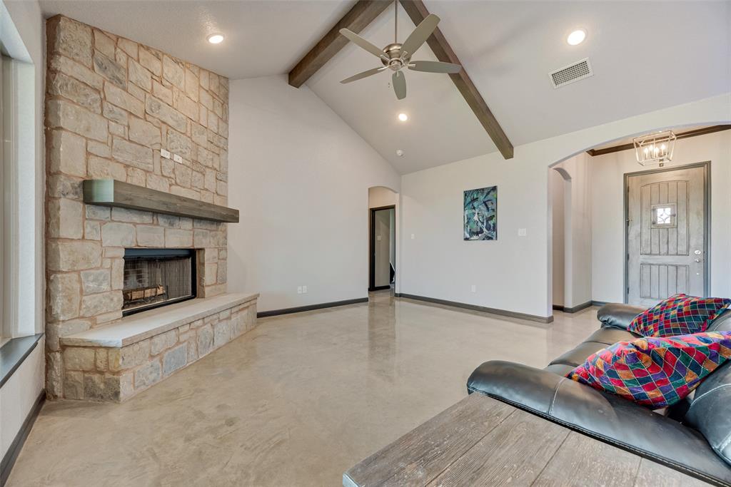 416 Christian Way Azle, TX 76020 - Photo 4 of 23 Living area with beamed ceiling, finished concrete flooring, arched walkways, a stone fireplace, and recessed lighting