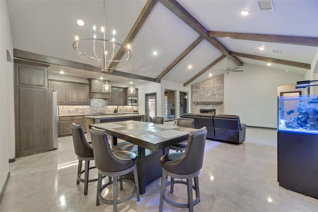 416 Christian Way Azle, TX 76020 - Photo 6 of 23 Dining area featuring a stone fireplace, beamed ceiling, high vaulted ceiling, recessed lighting, and finished concrete floors