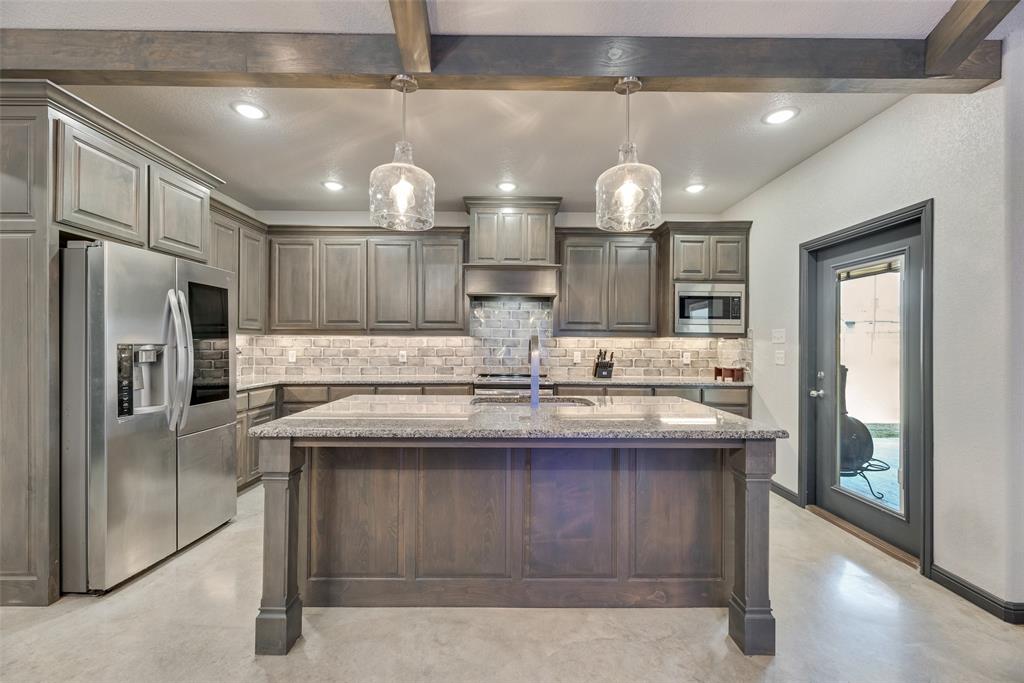 416 Christian Way Azle, TX 76020 - Photo 7 of 23 Kitchen with tasteful backsplash, appliances with stainless steel finishes, beamed ceiling, an island with sink, and light stone countertops