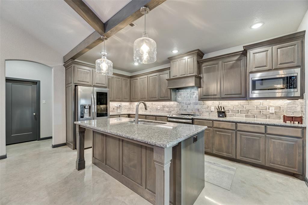 416 Christian Way Azle, TX 76020 - Photo 8 of 23 Kitchen with backsplash, beam ceiling, an island with sink, stainless steel appliances, and light stone countertops