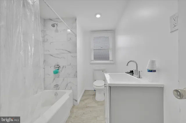a bathroom with a sink a toilet and bathtub