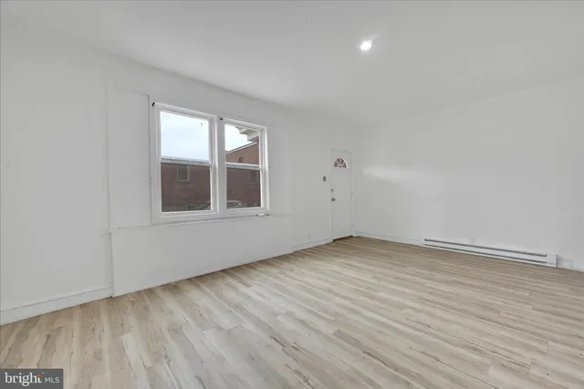 wooden floor in an empty room with a window