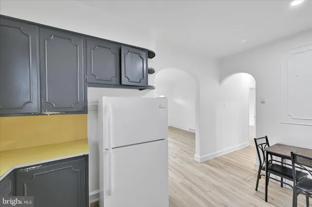 a kitchen with a refrigerator a stove and wooden floor