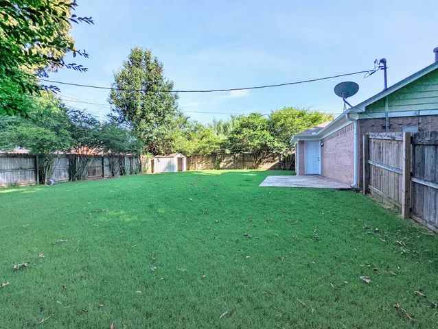 a view of a house with backyard and a tree