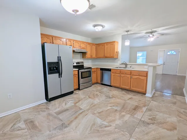 a large kitchen with cabinets and stainless steel appliances