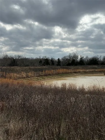 a view of a green field with wooden fence