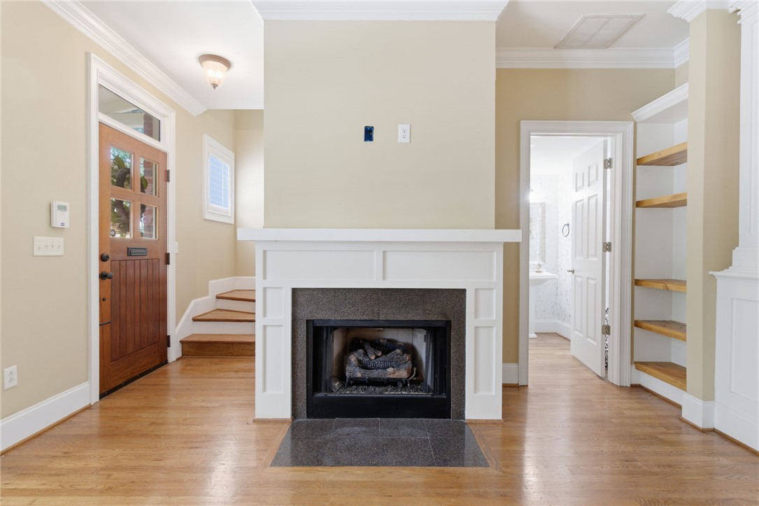 204 Butler Avenue Greenville, SC 29601 - Photo 10 of 26 A welcoming entryway showcases hardwood floors and a cozy fireplace with a detailed mantel.