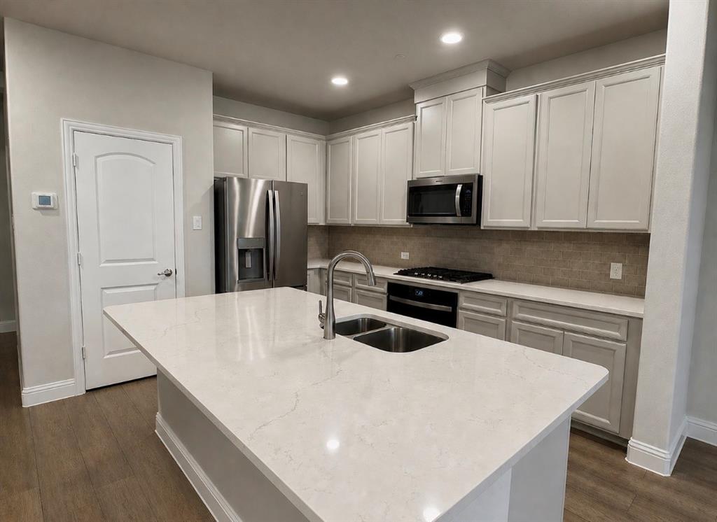 7849 Sunset Boulevard Rowlett, TX 75088 - Photo 4 of 13 a kitchen with stainless steel appliances a stove microwave and refrigerator