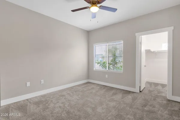 an empty room with closet and windows