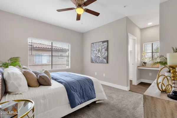 a bedroom with a large bed and a chandelier fan