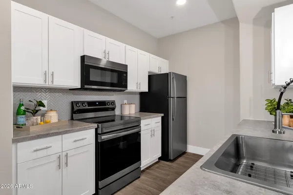 a kitchen with appliances a sink and cabinets