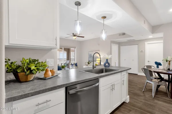 a kitchen with stainless steel appliances kitchen island granite countertop a stove a sink a microwave and a white cabinets