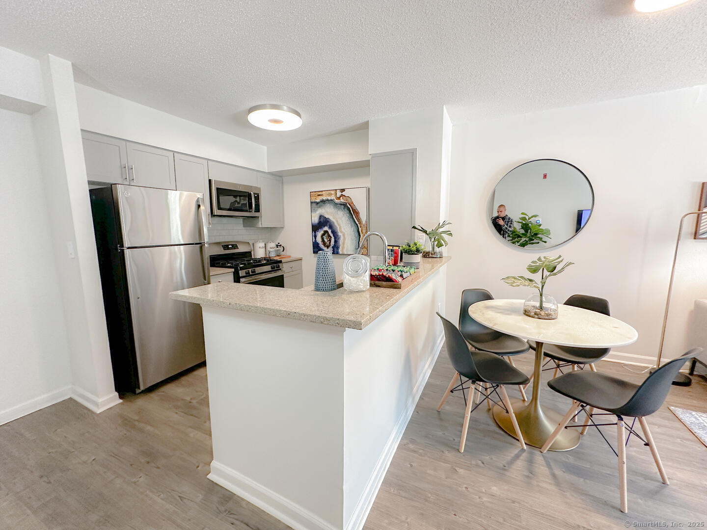 52 Forest Street, Unit 1402 Stamford, CT 06901 - Photo 16 of 23 a room with a table chairs a refrigerator and a sink