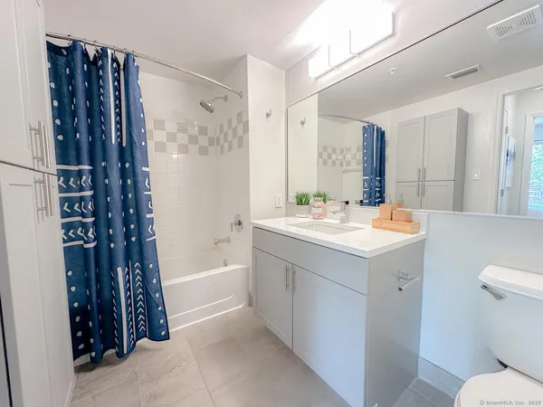 a bathroom with a double vanity sink toilet and shower
