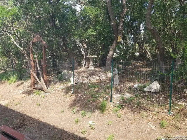 a view of a big yard with a house in the background
