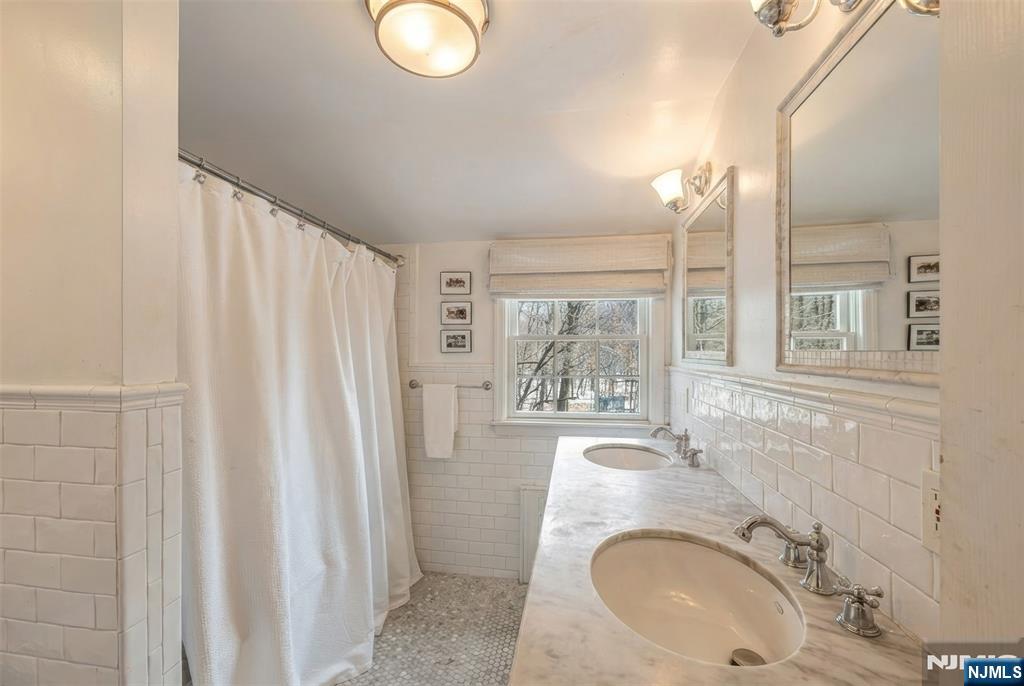 8 White Pine Road Upper Saddle River, NJ 07458 - Photo 33 of 50 a bathroom with a sink a mirror and a shower
