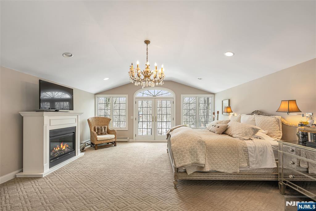 8 White Pine Road Upper Saddle River, NJ 07458 - Photo 37 of 50 a bedroom with a bed and a chandelier
