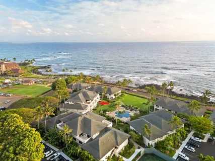 an aerial view of ocean and residential houses with outdoor space