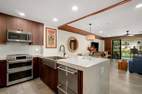 a kitchen with sink a microwave and cabinets