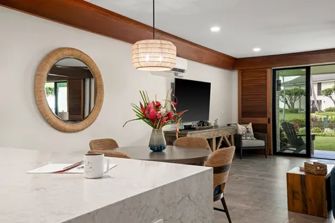 a living room with fireplace furniture and a potted plant