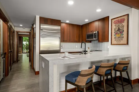 a kitchen with kitchen island a sink stove and refrigerator