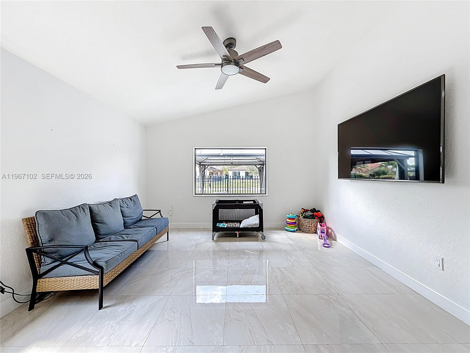 21102 Southwest 92nd Court Cutler Bay, FL 33189 - Photo 13 of 40 a living room with furniture and a flat screen tv