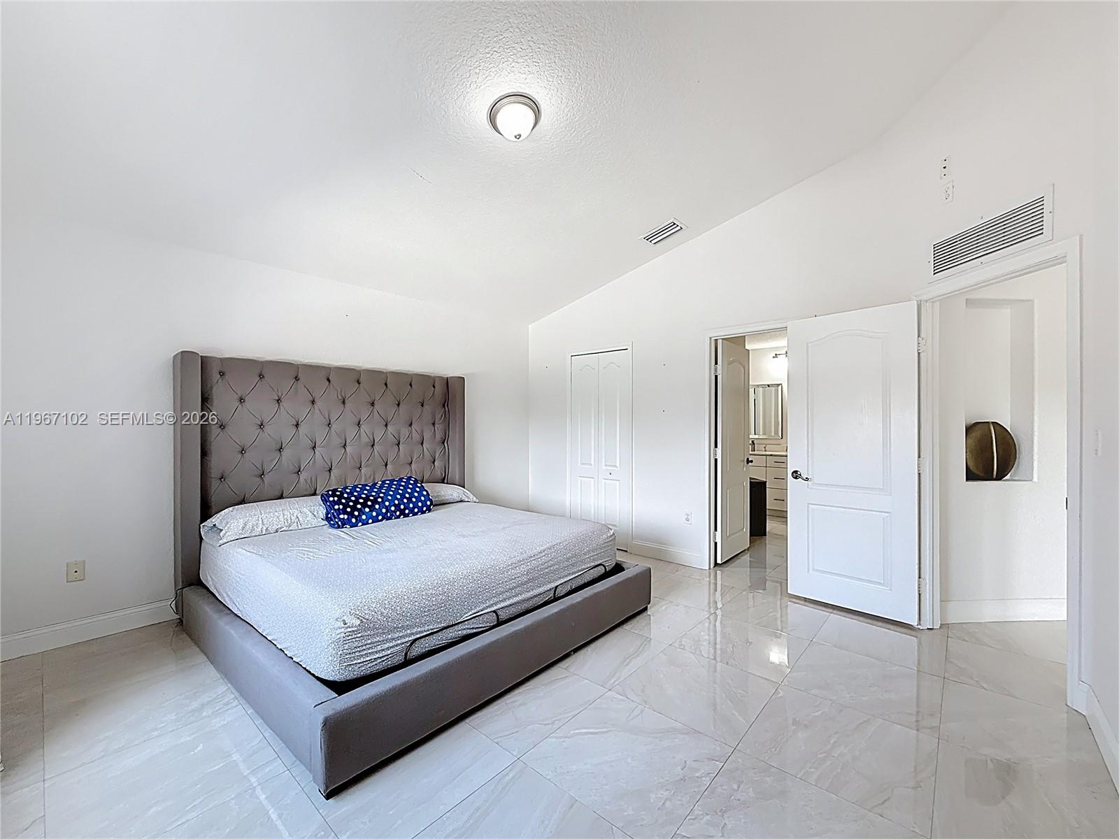 21102 Southwest 92nd Court Cutler Bay, FL 33189 - Photo 22 of 40 a spacious bedroom with a bed and a table in it