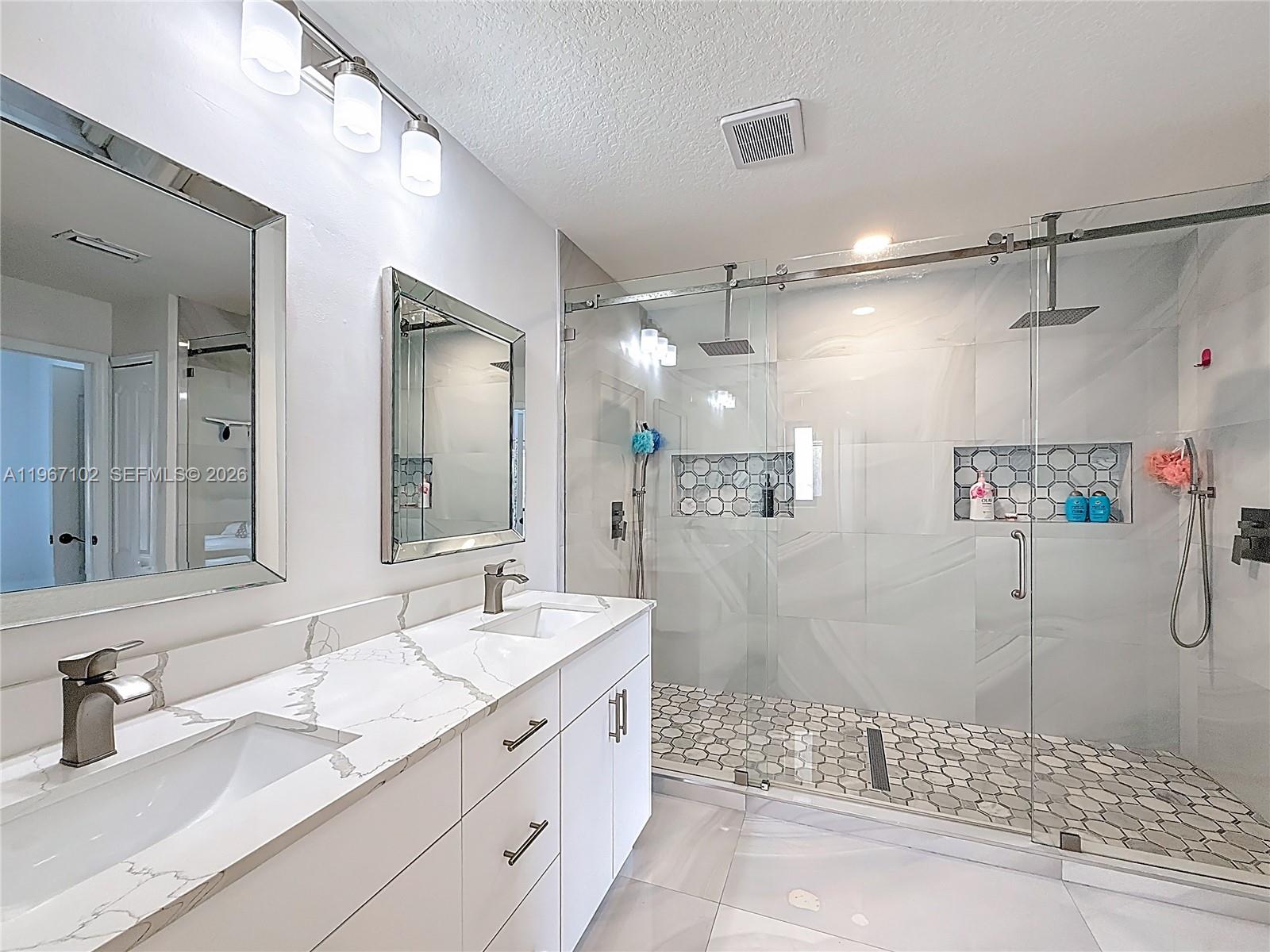 21102 Southwest 92nd Court Cutler Bay, FL 33189 - Photo 25 of 40 a bathroom with a granite countertop sink mirror and shower