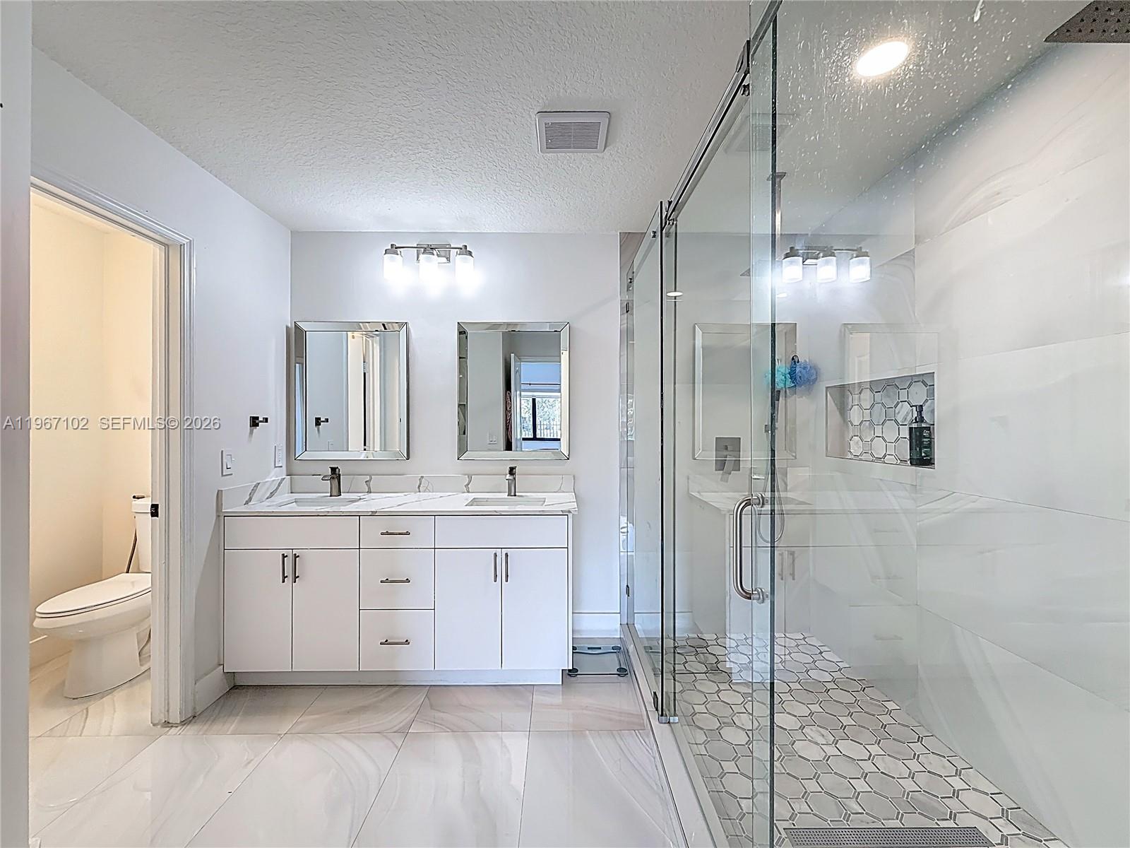 21102 Southwest 92nd Court Cutler Bay, FL 33189 - Photo 26 of 40 a spacious bathroom with a granite countertop sink a toilet and shower