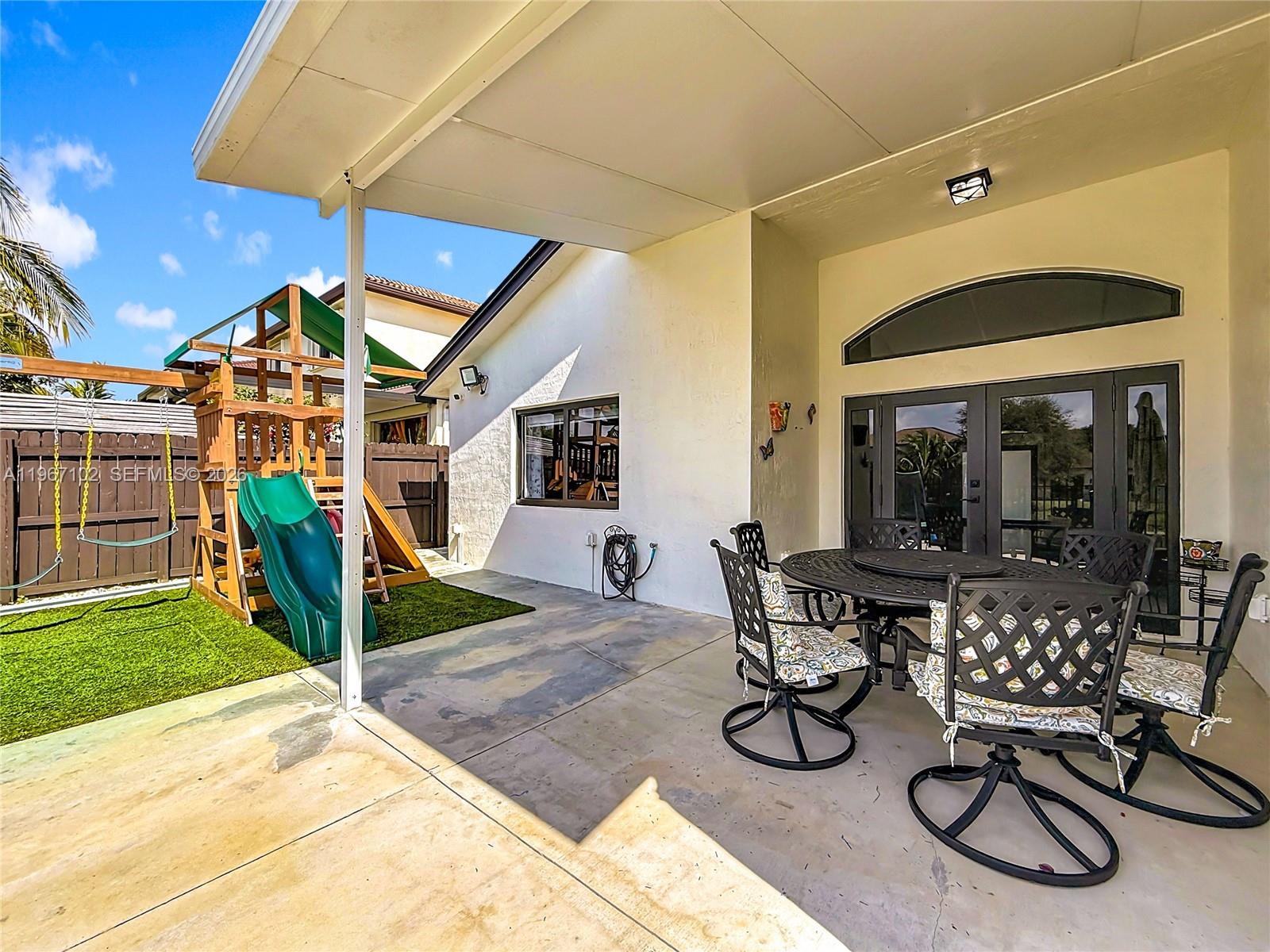 21102 Southwest 92nd Court Cutler Bay, FL 33189 - Photo 29 of 40 a patio with a table and chairs