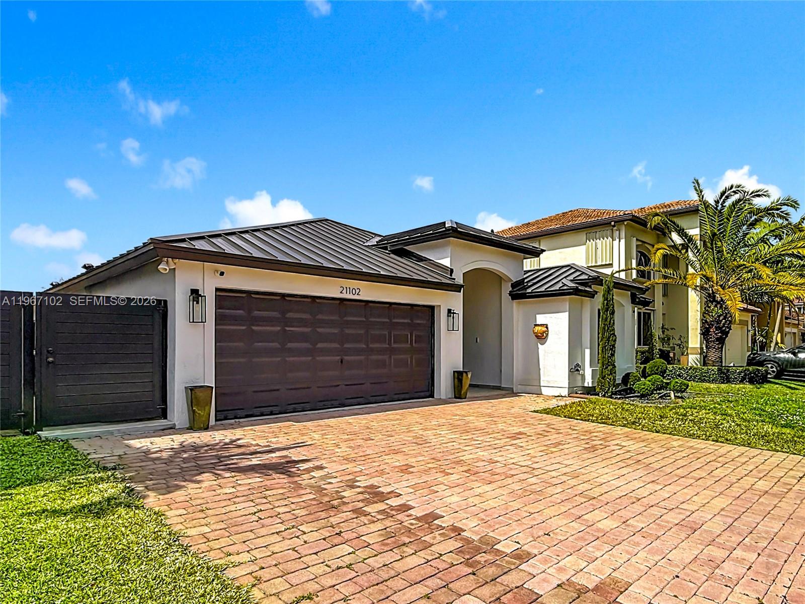 21102 Southwest 92nd Court Cutler Bay, FL 33189 - Photo 3 of 40 a front view of a house with a yard and garage