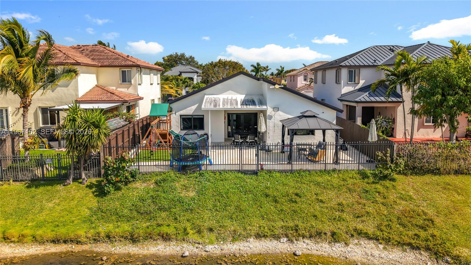 21102 Southwest 92nd Court Cutler Bay, FL 33189 - Photo 34 of 40 a view of a white house with a big yard and large trees