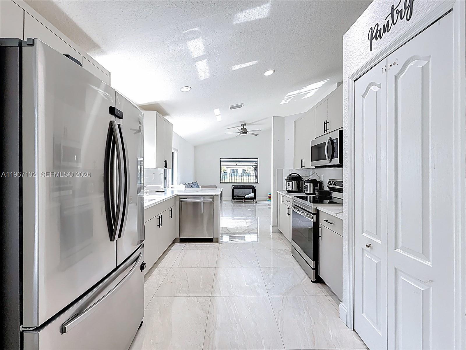 21102 Southwest 92nd Court Cutler Bay, FL 33189 - Photo 9 of 40 a kitchen with white cabinets and stainless steel appliances
