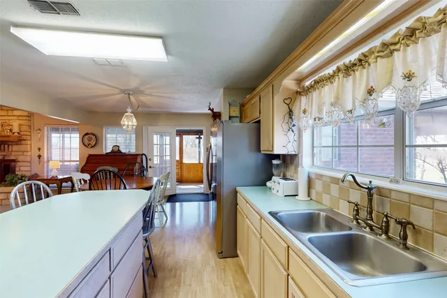 a living room with stainless steel appliances kitchen island granite countertop furniture and a wooden floor