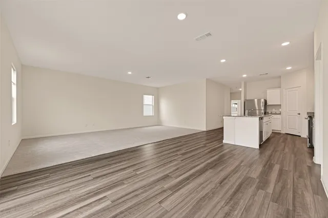 a kitchen with granite countertop a stove a sink and a refrigerator